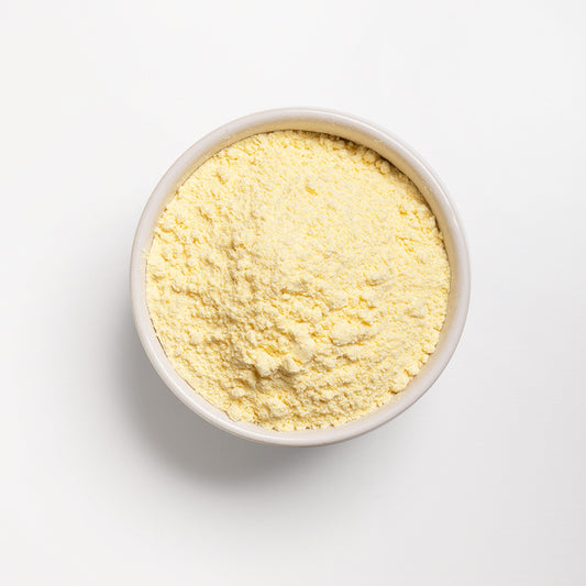 A bowl of yellow corn flour on a white background.