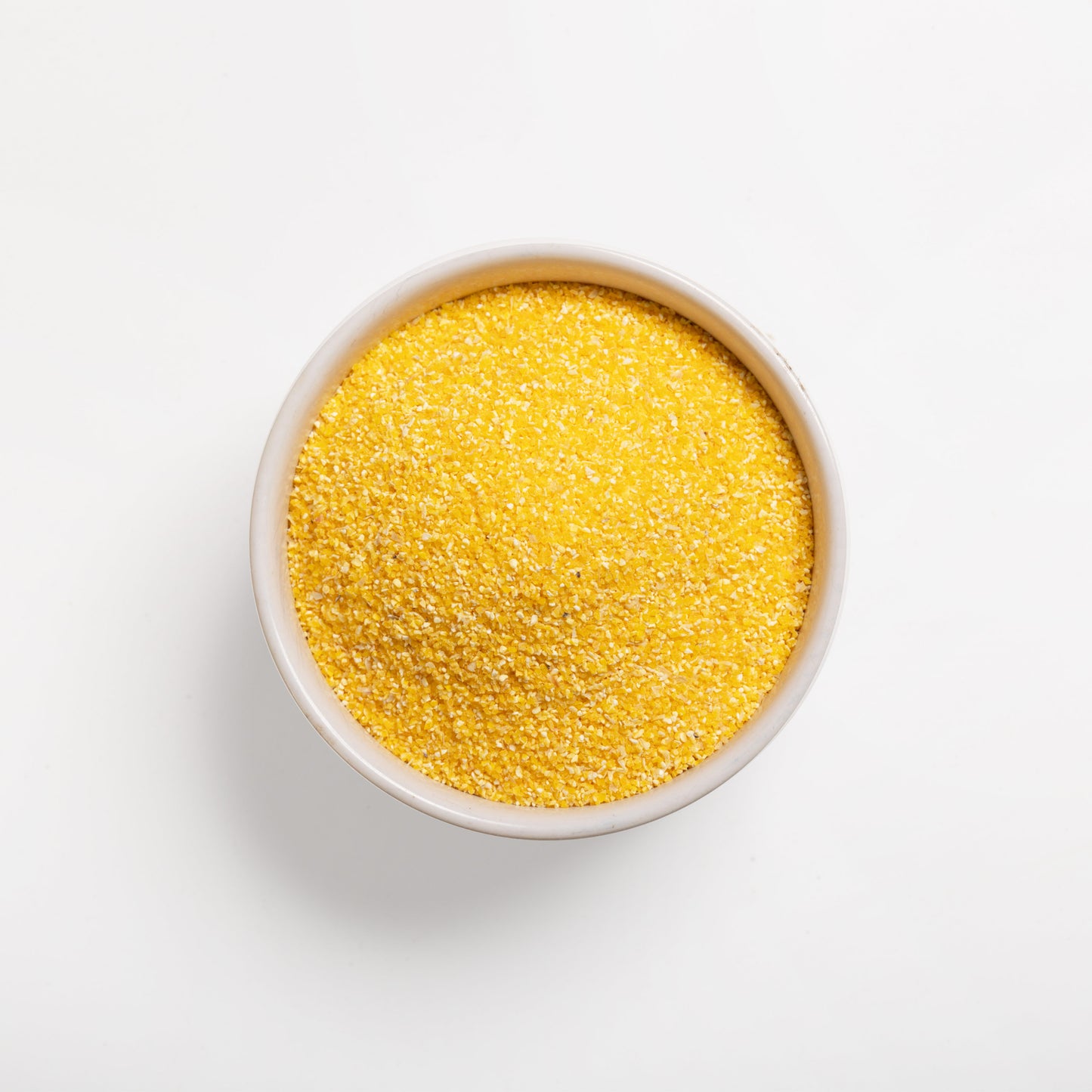 A bowl full of coarse yellow grits (#18) on a white background.