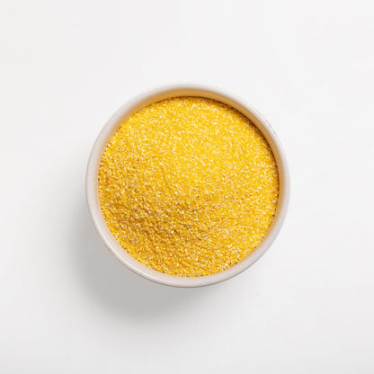 A bowl full of coarse yellow grits (#18) on a white background.