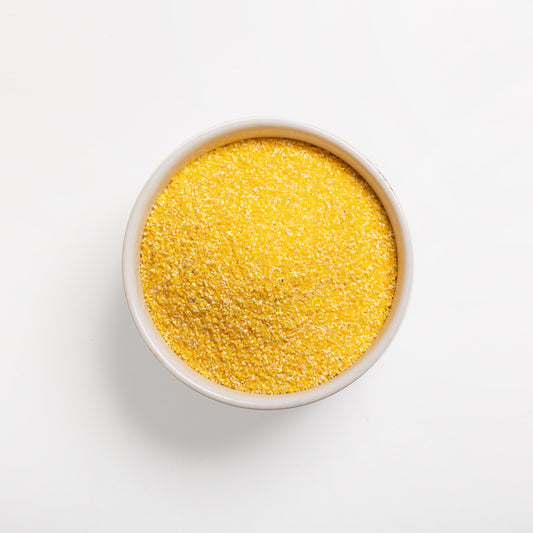 A bowl full of coarse yellow grits (#18) on a white background.