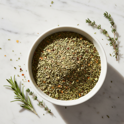 A white bowl filled with Italian Seasoning featuring fresh herbs on the side 